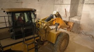 Погрузчик Caterpillar 988K с ковшом для блоков работает в подземных мраморных карьерах.