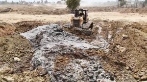 Строительство огромного канала: мощный бульдозер Komatsu D60P в действии совместно с самосвалами.