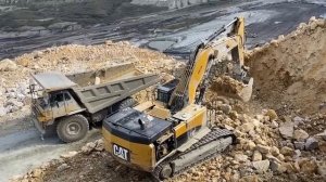 Экскаватор Cat 385C Загружает в самосвалы Cat 775E измельченные материалы -
