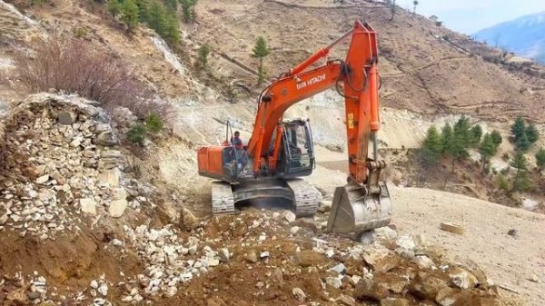 Expert Operator Building Narrow Road on Snowy Hill Edge
