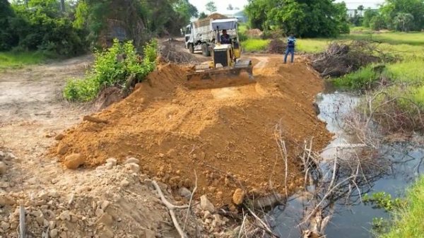 Nicely Start building new Road by dump truck unloading soil into deep water and bulldozer pushing