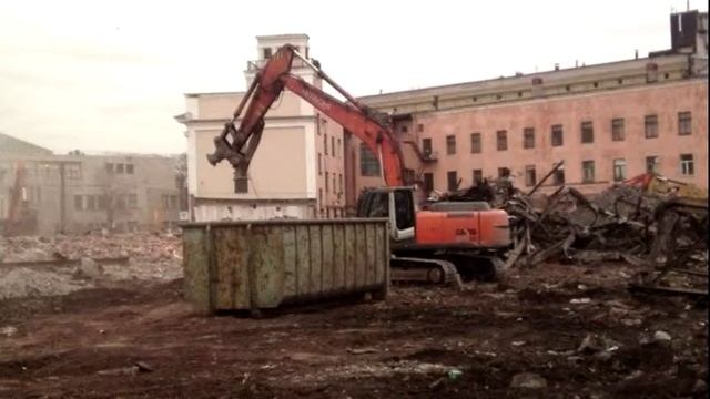 Экскаватор демонтирует здание