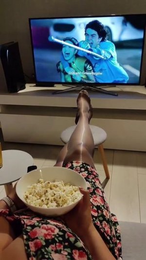 Девушка в капроновых колготках смотрит телевизор ножки в тонких копроне