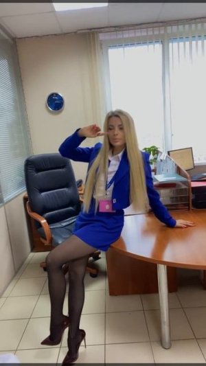 В офисе в синей юбке в колготках на каблуках