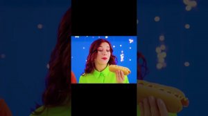 Девочка откусила кусочек горячей сосиски с горчицей.