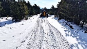 Как грейдер Deere 670 расчищает снег на горных дорогах, подверженных оползням