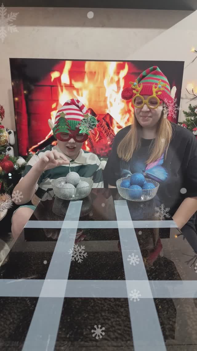 Мама и Данил играют в новогодние крестики-нолики.