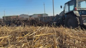 Синий трактор с ковшом возит землю и газон