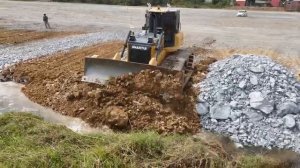 Плавный процесс преобразования великолепной земли: Умелый бульдозер, передвигающий камни, ограничива