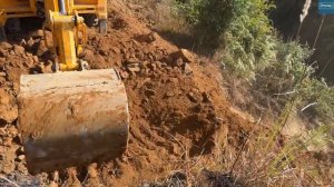 Страшно крутой склон -Строительные работы на горной дороге с использованием экскаватора JCB