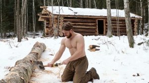 Мужчина в одиночку строит дом в северном лесу.