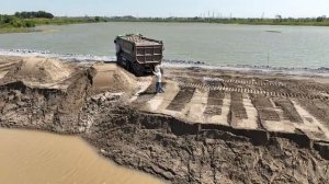 Песок засыпают в озеро бульдозером SHANTUI, умело раздвигая его