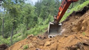 Excavator Backhoe Cutting Rocky Hillside to Build a Narrow Mountain Road – 2