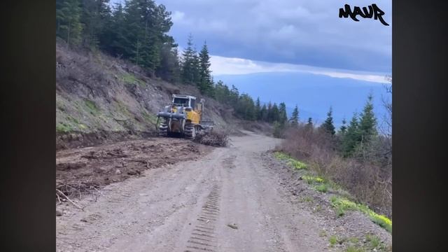 Огромный бульдозер строит крутую горную дорогу смотреть онлайн
