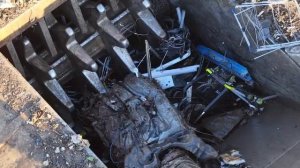 Вид с беспилотника на склад металлолома: мощная машина загружает автомобили и металлолом в устройств