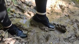 Девушка в чёрных туфлях ходит по грязи