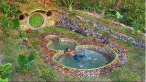 Креативный домик в стиле хоббитов с бассейном, построенный в лесу, примитивными методами.