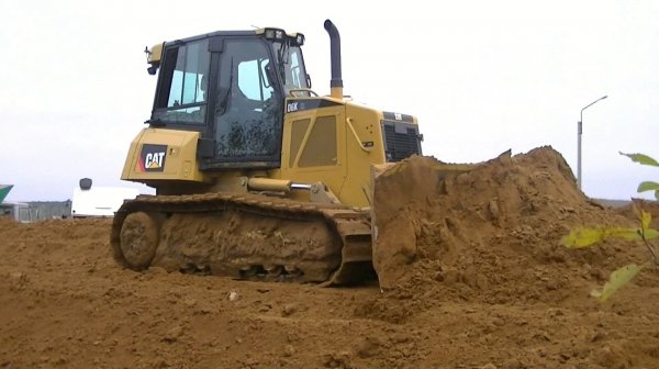 Бульдозер Cat D6K XL толкает песок