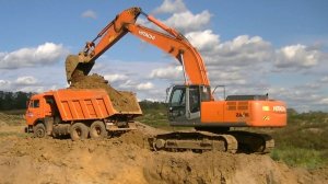 Экскаватор Hitachi Zaxis 330-3 грузит Камаз в карьере