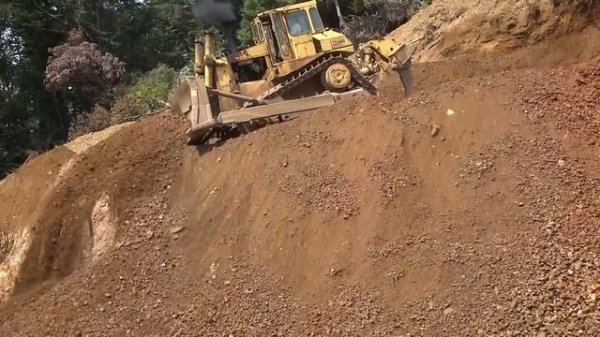 The old Caterpillar D8L bulldozer pushing chert rock in Japan