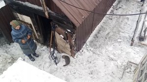 Зимний труд: чистка снега с крыши дома"