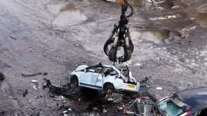 В этой машине Liebherr используется тяжелая металлическая пластина для расплющивания автомобилей,