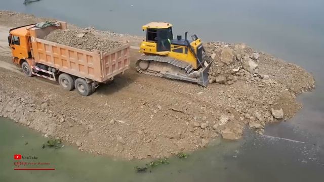 Замечательное строительство бульдозерами, которые усердно расталкивают гравий, строят дороги, выполн