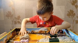Играем в песочнице. Серёжа строит домик для котика