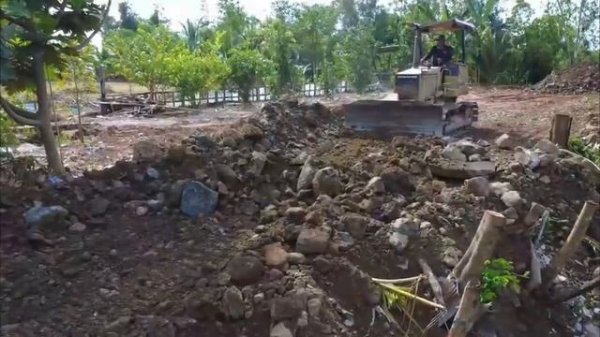 Landslide Sighting The KOMATSU Bulldozer Pushes The Rock Against The Shore.