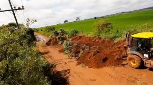 Экскаватор-погрузчик, открывающий траншею для стока воды.