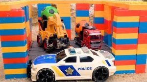 Бибо играет с грузовиками и экскаваторами, а также с тюрьмой из разноцветных блоков