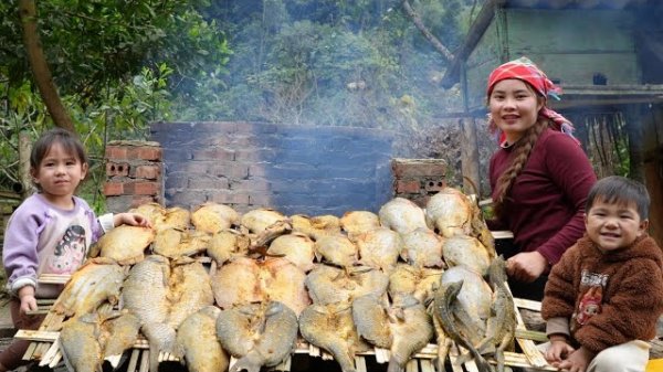 Готовлю копченую рыбу для продажи на рынке вместе с моим маленьким сыном. Дуонг. Вьетнам