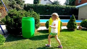 Настя прячется в цветных бочках и смешит масками героев из мультиков