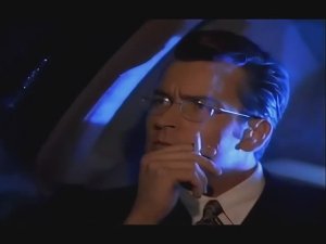 Мужчина с очках костюме едет в машине курит смотрит в окно