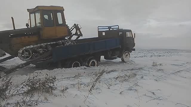 Бульдозер ДТ-75 съезжает с кузова Камаза