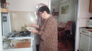 Женщина на кухне готовит еду. У мужа свои дела