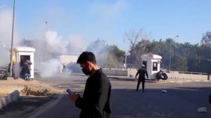 Протестующие в Багдаде забрасывают полицейских камнями. Те в ответ применяют дымовые шашки и ...