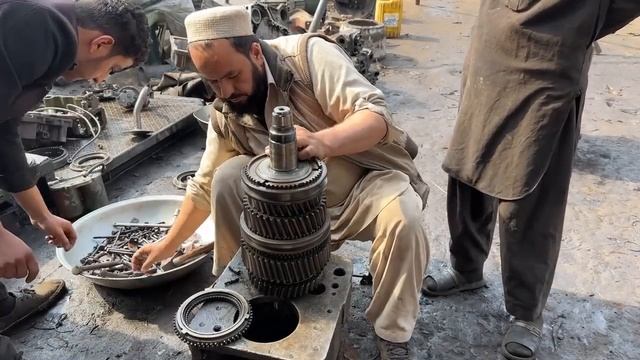 Мастерская по ремонту техники производит переборку коробки передач грузового автомобиля.