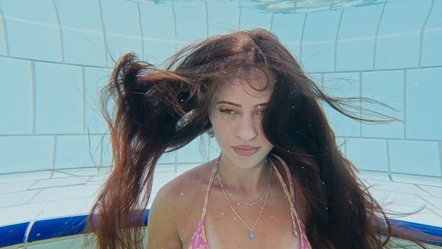 Девушка купается в  бассейне