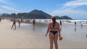 Красивые женщины  с красивой фигурой в купальнике играют в пляжный теннис.