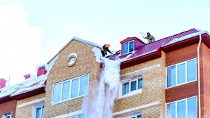 В Когалыме убирают снежные шапки с крыш домов