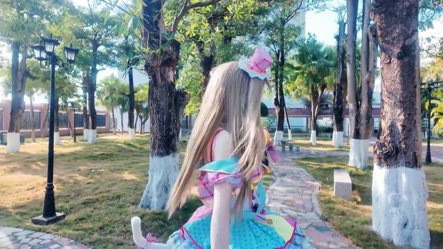 Миленькая кошкодевочка-кигуруми гуляет по парку.