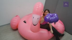 Lila blows and pops a blossom balloon on flamingo floaties