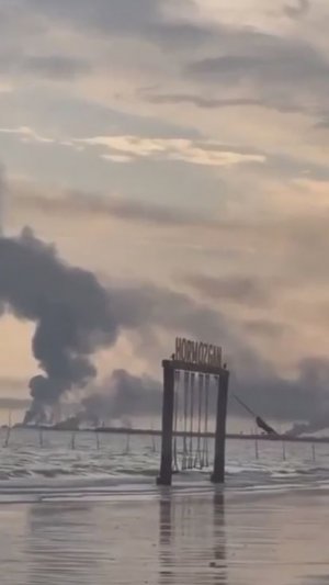 Иранская девочка качается на качелях на фоне дыма после бомбежек