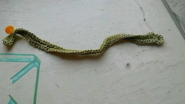 Браслет зелёного цвета, связанный крючком и застёгивающийся на пуговку