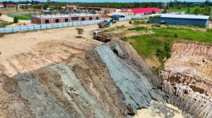 The act of dumping soil and garbage into a deep pit with a team of machinery