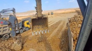 The excavator is performing full loading, filling dump trucks with mined material. taracks