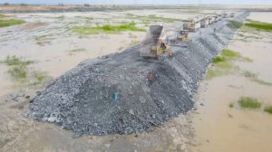 Great action! Bulldozers pour rocks into mountains, clear lakes, expand land, and create a long, ama