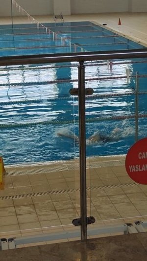 Сын плавает в бассейне