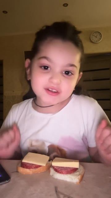 Девочка держит бутерброды говорит я обжора потому что я когда иду спать сразу хочу есть